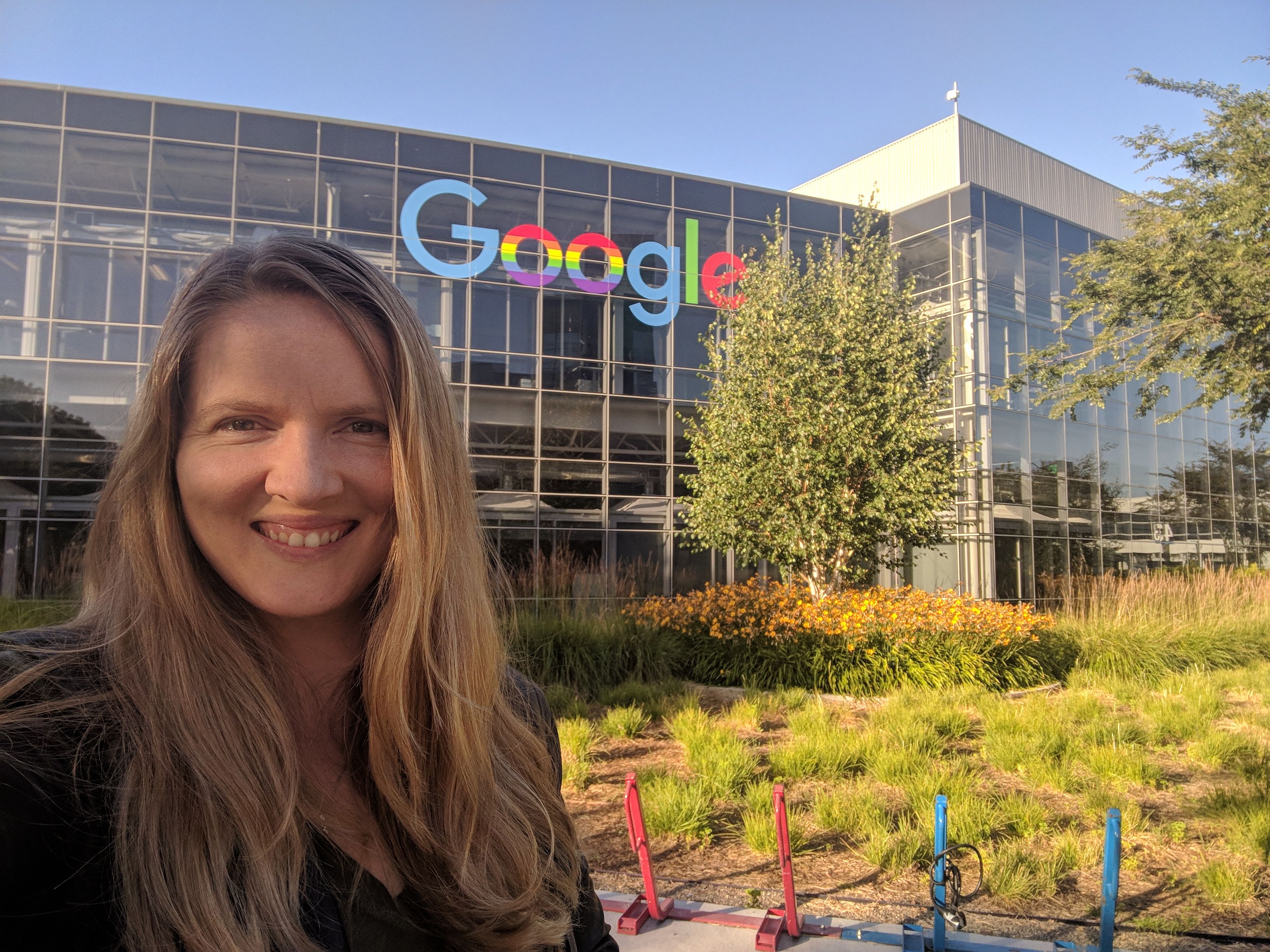 Diana standing in front of a office building with Google on it.